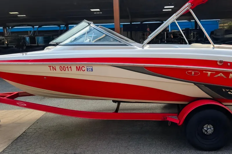 The Image of 2011 Tahoe Q5L I/O boat on red trailer, parked indoors. - 0