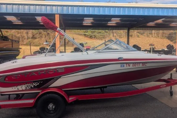 Slide: The Image of 2011 Tahoe Q5L I/O boat with red and white design on a trailer. - 10