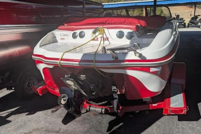 Slide: The Image of 2011 Tahoe Q5L I/O boat in red and white, parked on a trailer. - 4