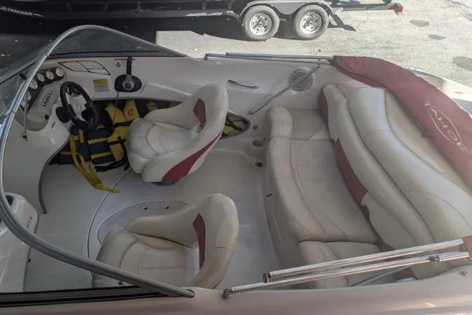 Slide: The Image of 2011 Tahoe Q5L I/O boat interior with white and red seating, steering wheel, and life jackets. - 6