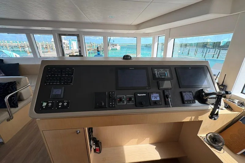 Slide: The Image of Control panel of a 2020 Silent 55 yacht with navigation screens and ocean view. - 17
