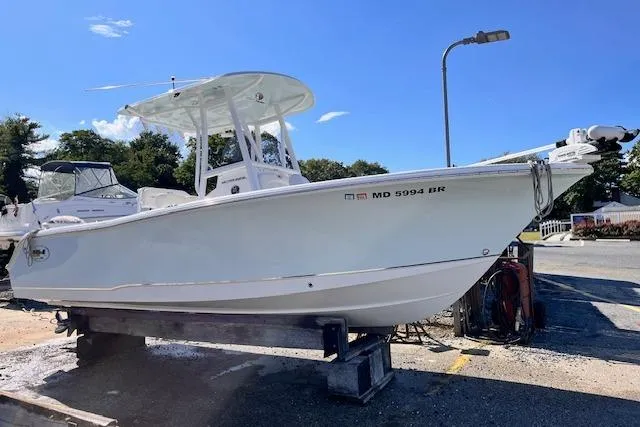 The Image of 2021 Sea Hunt Ultra 229 boat on a trailer, parked outdoors under a clear blue sky. - 0