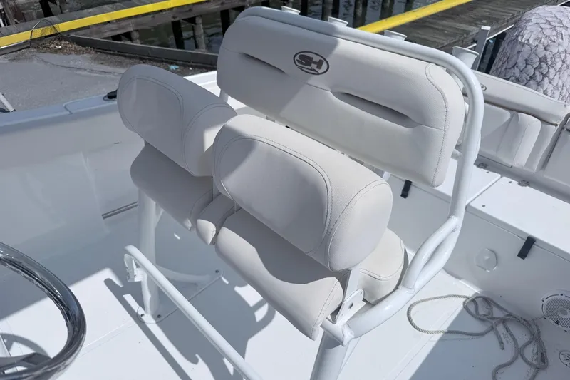 Slide: The Image of 2021 Sea Hunt Ultra 229 boat interior with white cushioned seating and steering wheel. - 12