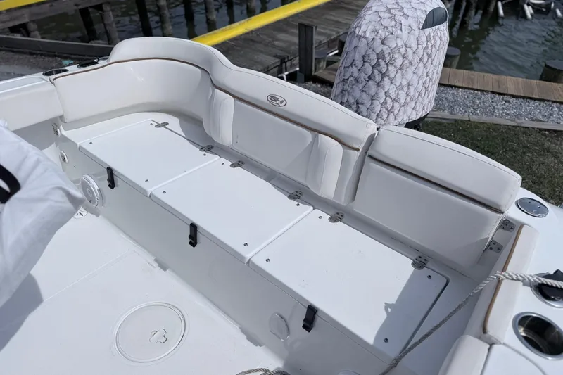 Slide: The Image of 2021 Sea Hunt Ultra 229 boat interior with white seating and storage compartments. - 13