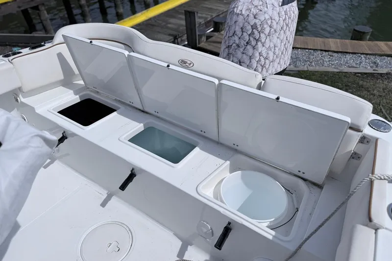 Slide: The Image of 2021 Sea Hunt Ultra 229 boat storage compartments open, showcasing interior features. - 14
