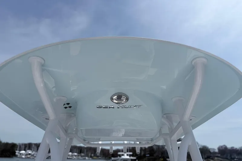 Slide: The Image of 2021 Sea Hunt Ultra 229 boat canopy with logo, under a clear blue sky. - 16