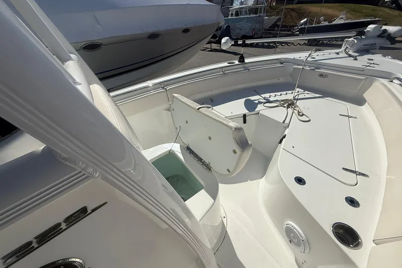 Slide: The Image of 2021 Sea Hunt Ultra 229 boat interior with open storage compartment and seating area. - 18