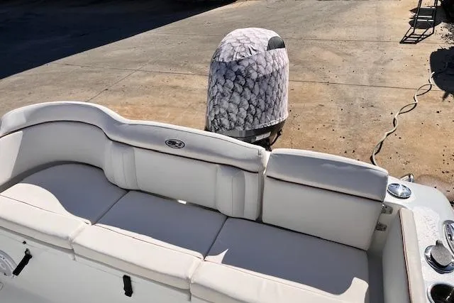 Slide: The Image of 2021 Sea Hunt Ultra 229 boat with cushioned seating and covered outboard motor. - 7