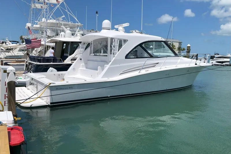 The Image of 2020 Hatteras GT45X yacht docked in marina under clear blue sky. - 0