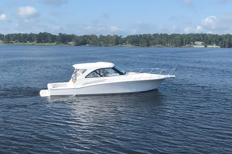 Slide: The Image of 2020 Hatteras GT45X yacht cruising on a calm lake under a clear sky. - 11