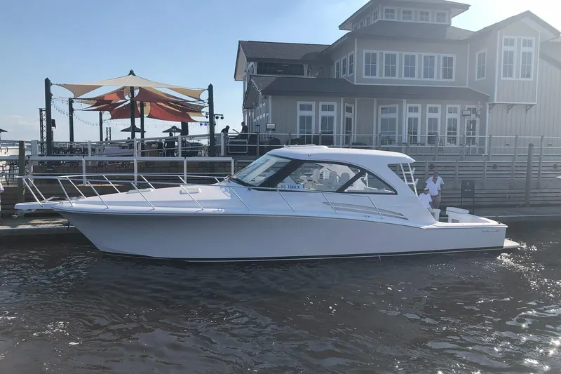 Slide: The Image of 2020 Hatteras GT45X yacht docked near waterfront building. - 2