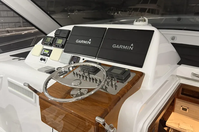 Slide: The Image of 2020 Hatteras GT45X yacht helm with Garmin navigation systems and polished wood finish. - 39