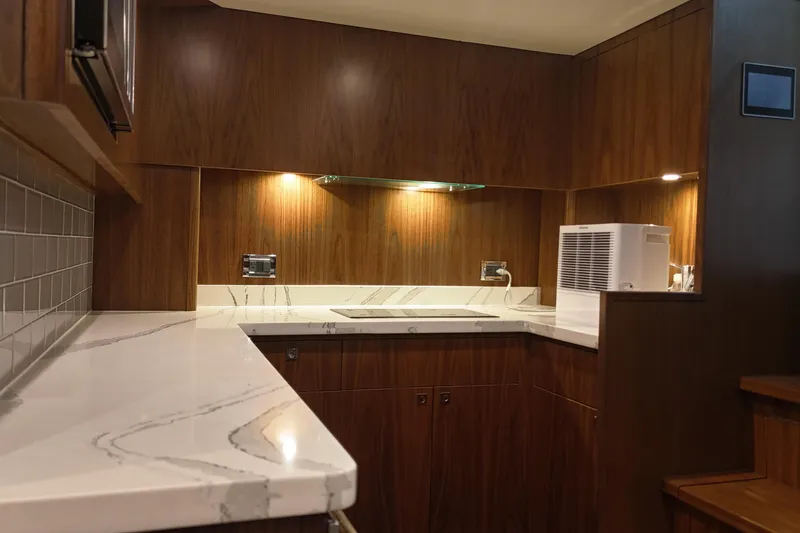 Slide: The Image of Luxurious 2020 Hatteras GT45X yacht interior kitchen with modern wood finish. - 44