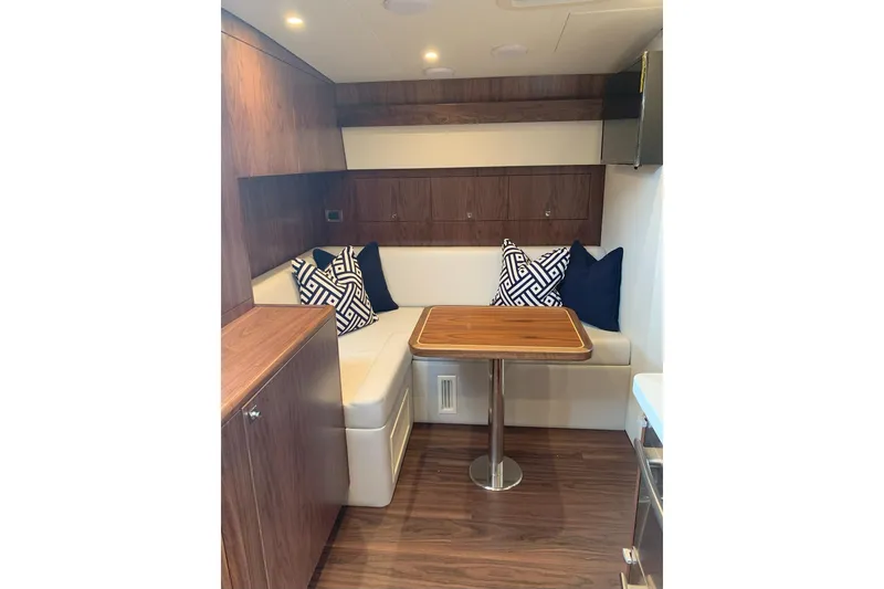 Slide: The Image of Interior of 2020 Hatteras GT45X yacht with cozy seating and wooden table. - 49