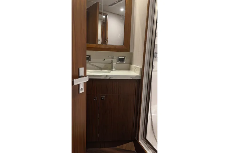 Slide: The Image of 2020 Hatteras GT45X yacht bathroom with wooden cabinetry and modern fixtures. - 62