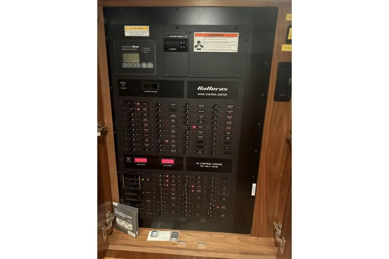 Slide: The Image of Electrical control panel of 2020 Hatteras GT45X yacht, featuring various switches and displays. - 63