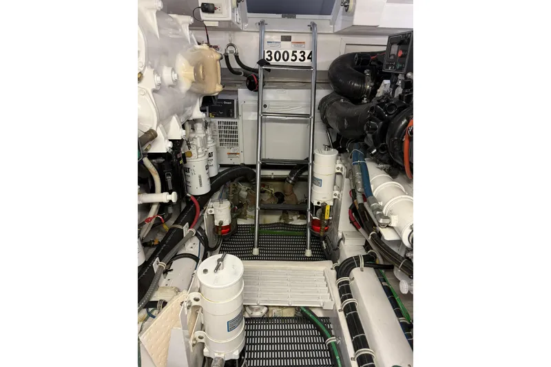 Slide: The Image of Engine room of 2020 Hatteras GT45X yacht with mechanical components and ladder. - 69