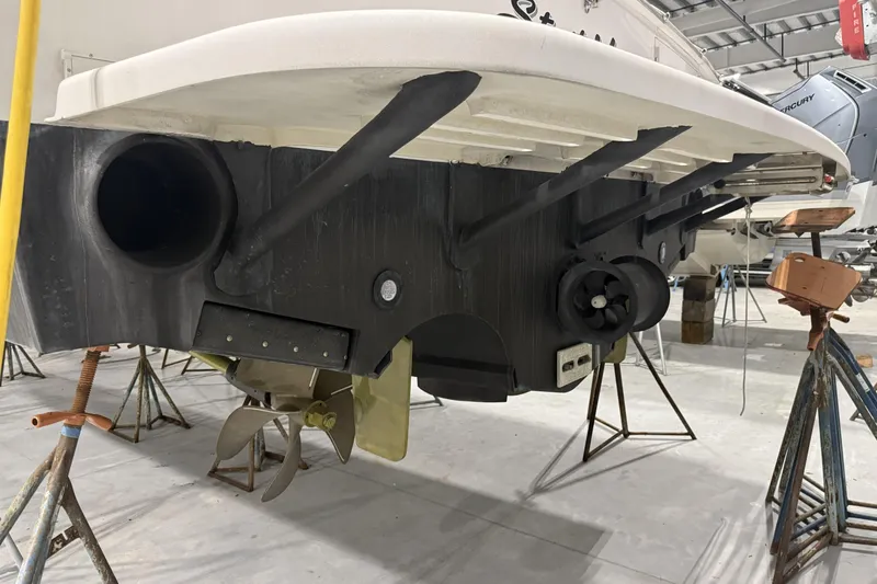 Slide: The Image of 2020 Hatteras GT45X boat underside in maintenance, showcasing propeller and hull details. - 74