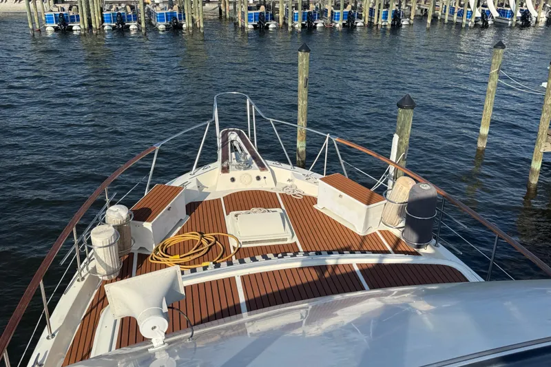 Slide: The Image of 1984 Hatteras 61 Cockpit MY yacht deck with wooden flooring, docked at marina. - 46