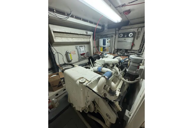 Slide: The Image of Engine room of 1984 Hatteras 61 Cockpit MY yacht, featuring mechanical components and wiring. - 51