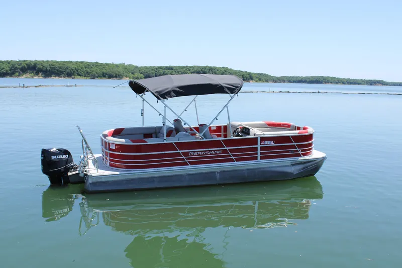 Slide: The Image of 2024 Berkshire 24RFX LE pontoon boat on a calm lake with scenic background. - 3