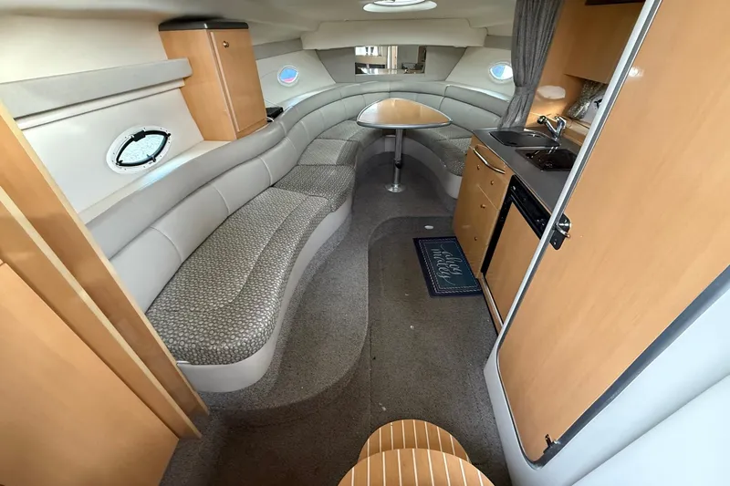 Slide: The Image of 2004 Maxum 3100 SE boat interior with kitchenette, seating, and dining area. - 12