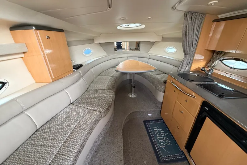 Slide: The Image of Interior of 2004 Maxum 3100 SE boat with seating, table, and kitchenette. - 13