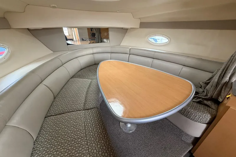 Slide: The Image of 2004 Maxum 3100 SE cabin interior with curved seating and wooden table. - 15