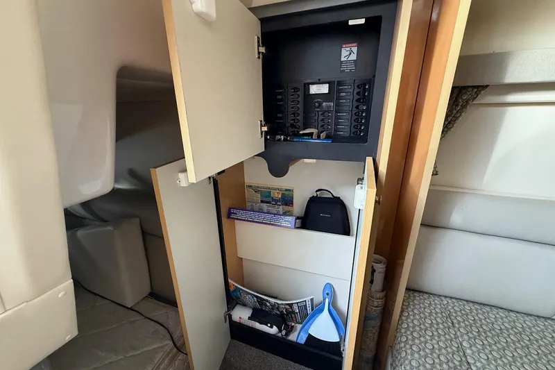 Slide: The Image of 2004 Maxum 3100 SE interior showing open cabinet with electrical panel and storage. - 20