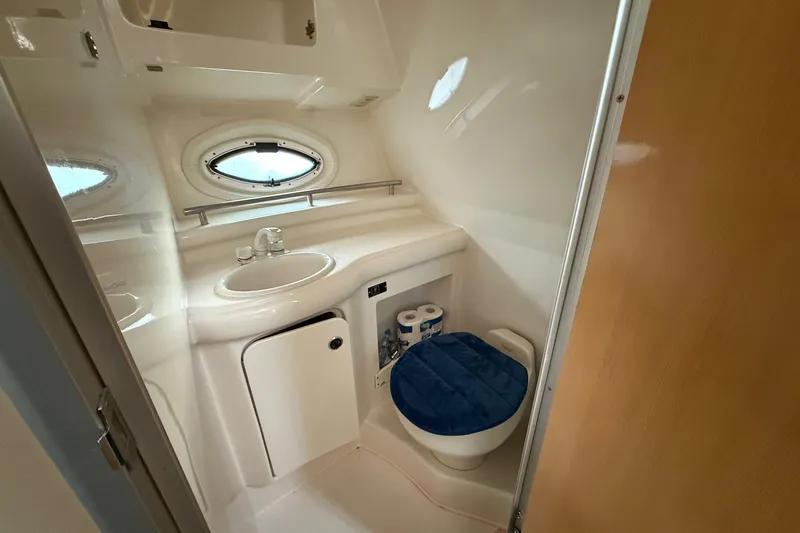 Slide: The Image of 2004 Maxum 3100 SE boat bathroom with sink, toilet, and porthole window. - 21