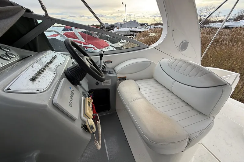 Slide: The Image of 2004 Maxum 3100 SE boat cockpit with steering wheel, Garmin device, and white seating. - 6