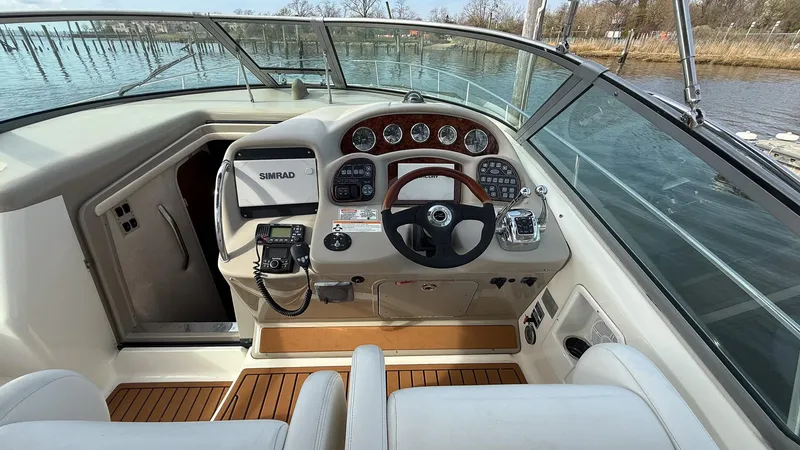 Slide: The Image of 2008 Sea Ray 340 Sundancer helm with modern controls and wood accents on a sunny day. - 10