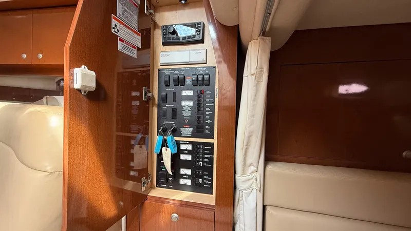 Slide: The Image of 2008 Sea Ray 340 Sundancer electrical panel with wooden cabinet and control switches. - 28