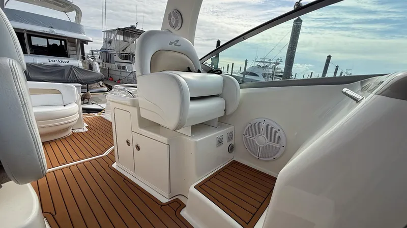 Slide: The Image of 2008 Sea Ray 340 Sundancer cockpit with white seating and wooden flooring. - 8