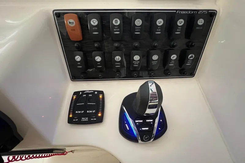 Slide: The Image of Control panel of 2023 Grady-White Freedom 275 boat with switches and joystick. - 13