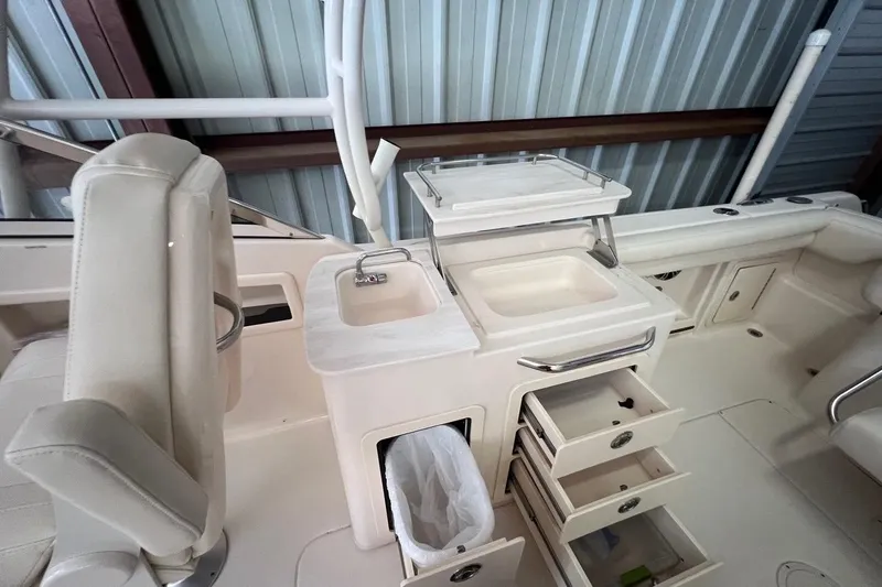 Slide: The Image of 2023 Grady-White Freedom 275 boat interior with sink, storage drawers, and seating. - 15
