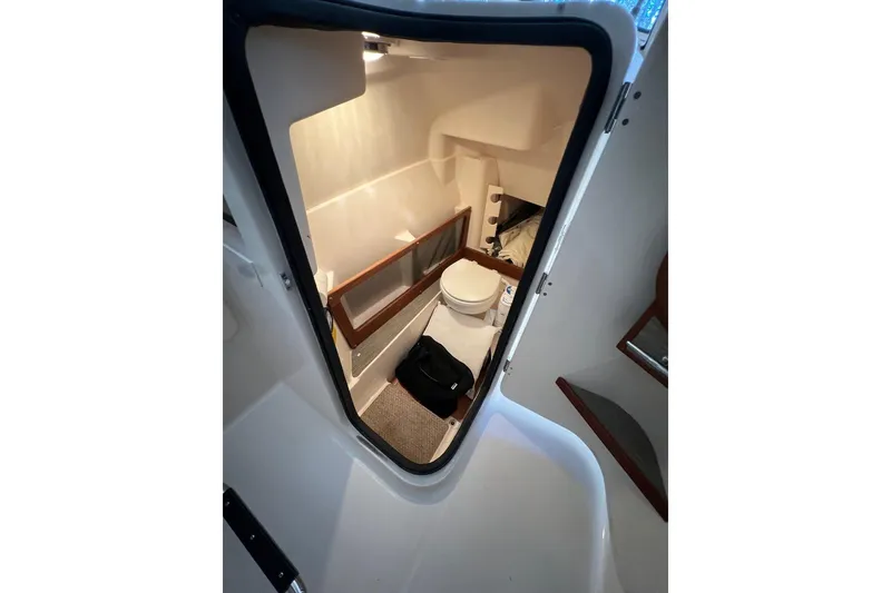 Slide: The Image of Interior cabin view of 2023 Grady-White Freedom 275 boat, featuring a compact bathroom. - 17