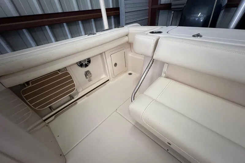 Slide: The Image of 2023 Grady-White Freedom 275 boat interior with beige seating and storage compartments. - 18