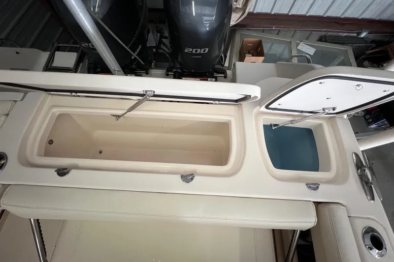 Slide: The Image of 2023 Grady-White Freedom 275 boat with open storage compartments and dual engines. - 21