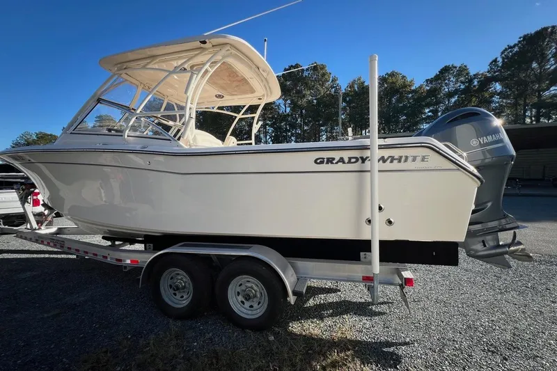 Slide: The Image of 2023 Grady-White Freedom 275 boat on trailer, featuring Yamaha engine, parked outdoors. - 25