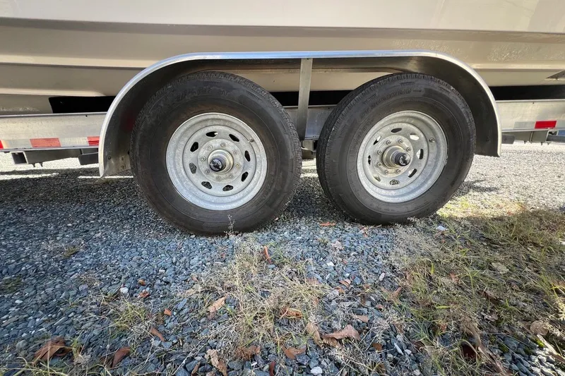 Slide: The Image of Trailer wheels of 2023 Grady-White Freedom 275 boat on gravel surface. - 29