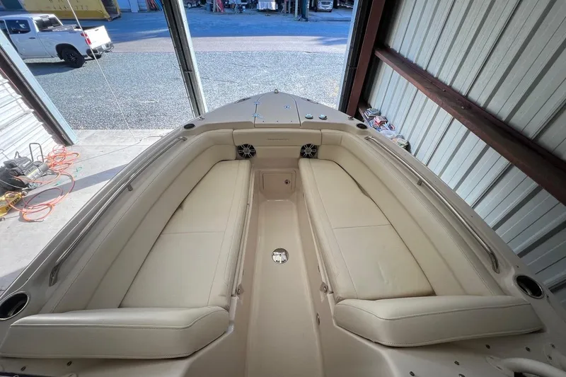 Slide: The Image of 2023 Grady-White Freedom 275 boat interior with beige seating in a garage setting. - 6