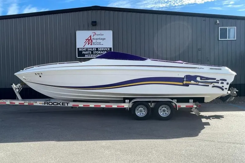 The Image of 2000 Baha MACH 1 speedboat on trailer, parked outside marine service center. - 1