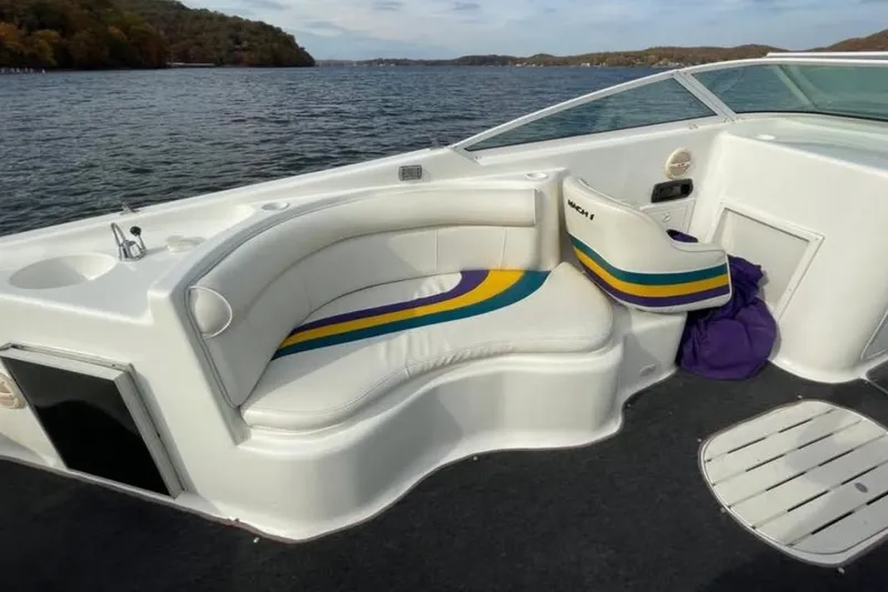 Slide: The Image of Baha MACH 1 boat interior, 2000 model, featuring white seating with colorful stripes on a lake. - 11