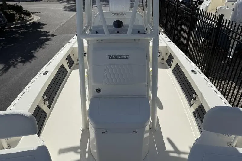 Slide: The Image of 2026 Pathfinder 2200 TRS boat interior with seating and console, parked outdoors. - 11