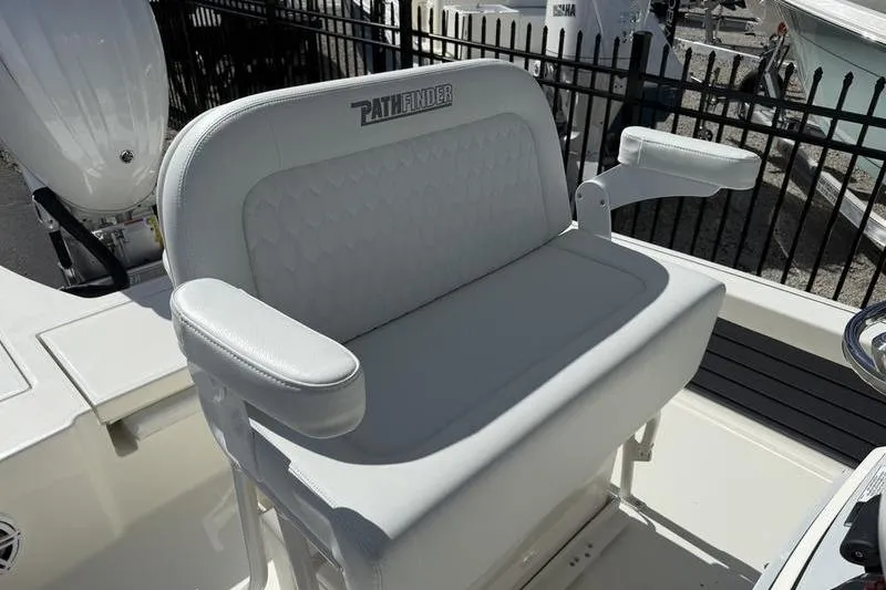 Slide: The Image of 2026 Pathfinder 2200 TRS boat seat with armrests, white upholstery, outdoor setting. - 17