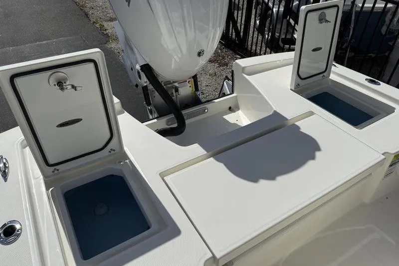 Slide: The Image of 2026 Pathfinder 2200 TRS boat with open storage compartments and outboard motor. - 24