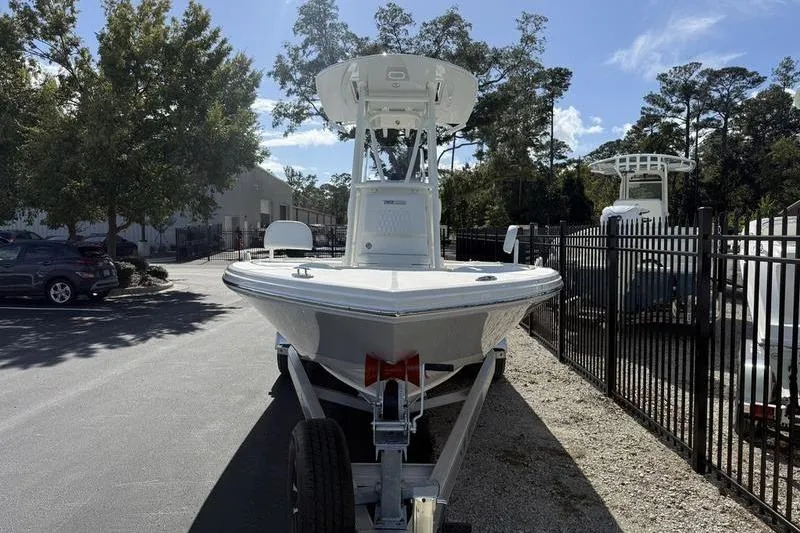 Slide: The Image of 2026 Pathfinder 2200 TRS boat on trailer, parked outdoors near trees and fence. - 3