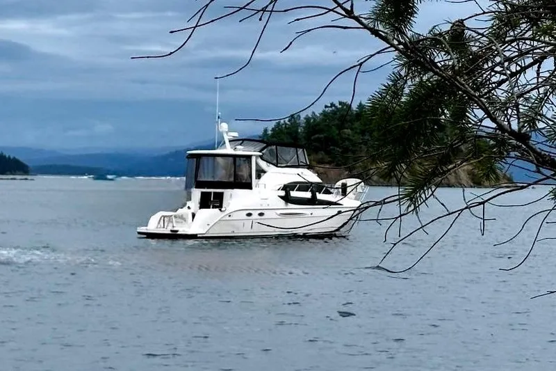 Slide: The Image of 2004 Meridian 459 Motoryacht on calm waters, surrounded by trees. - 1