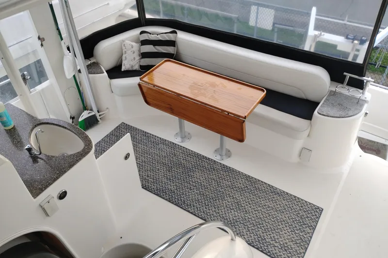 Slide: The Image of 2004 Meridian 459 Motoryacht interior with seating, table, and sink area. - 10